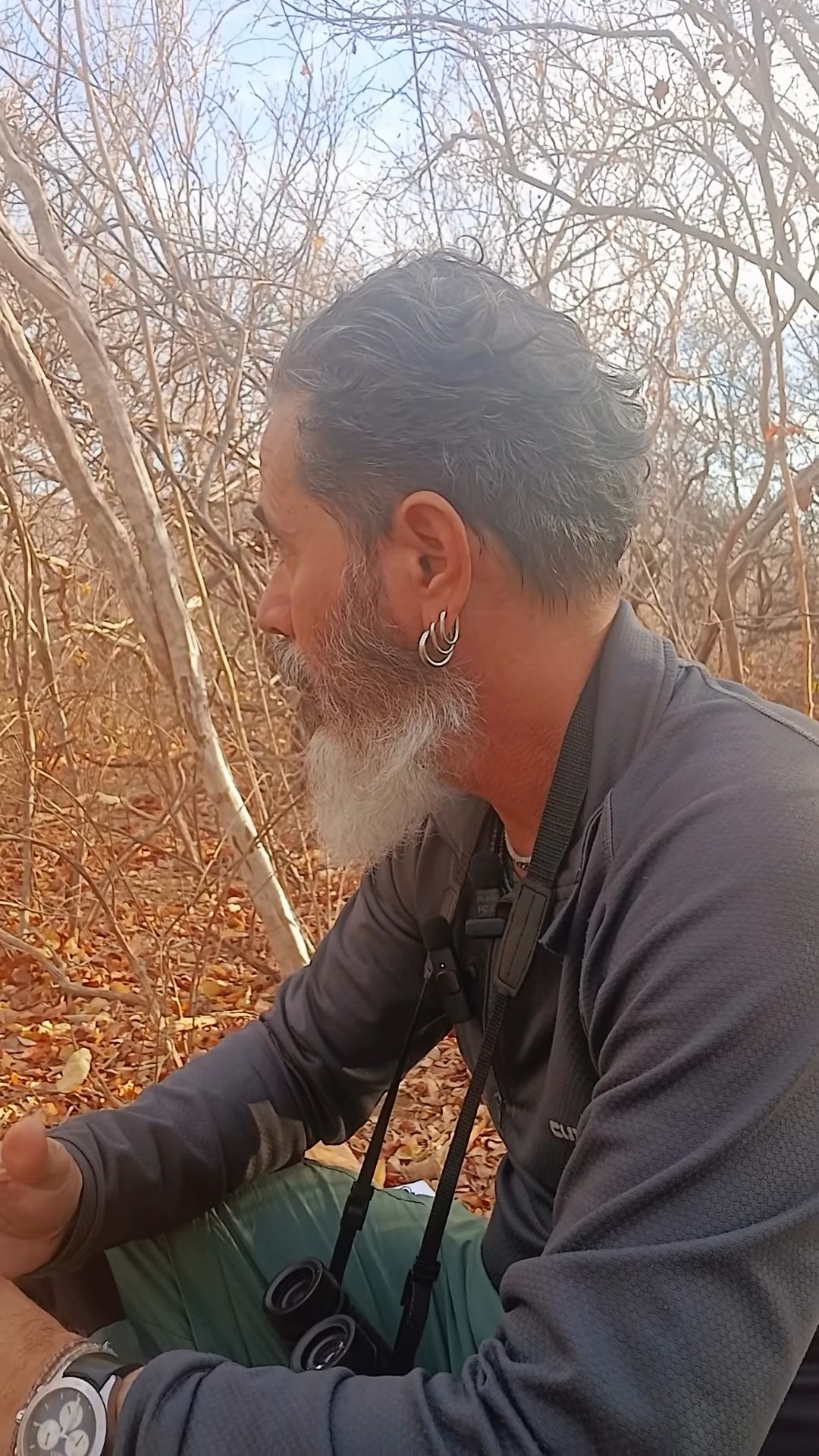 Biólogo agachado na vegetação seca da Caatinga
