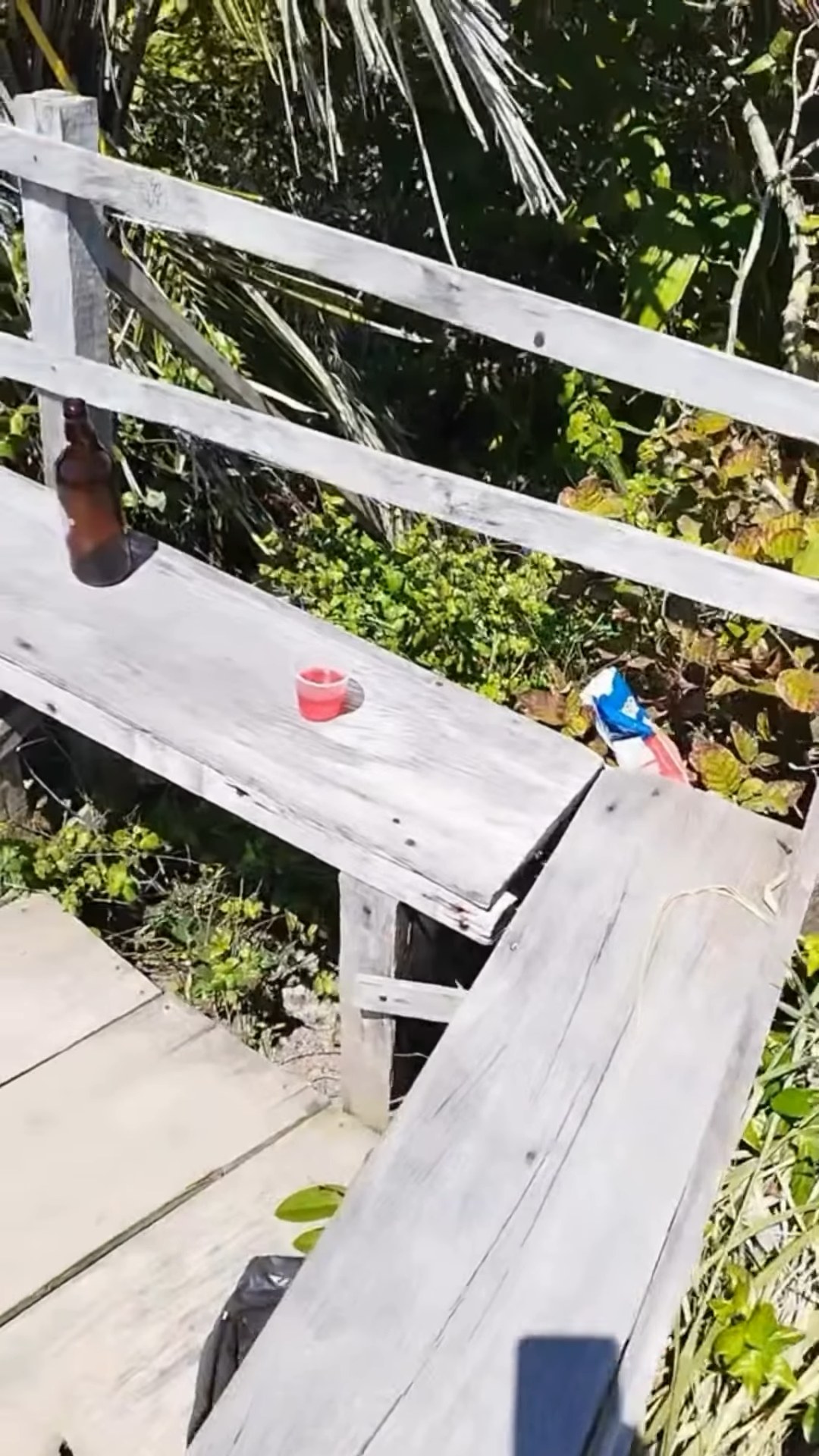 Garrafa e copos plásticos deixados nos bancos de madeira do Mirante de Carapibus