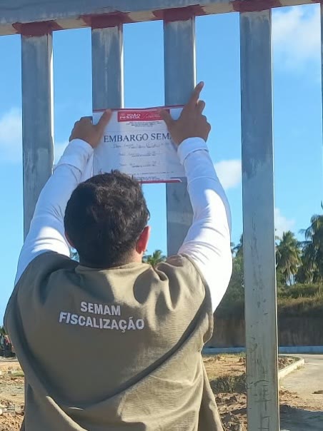 Auto de embargo sendo afixado na obra do Coqueiral Beach